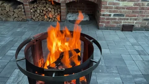 Enjoying a fire in the backyard as the sun sets over the neighborhood on a cool Video stock 339574878