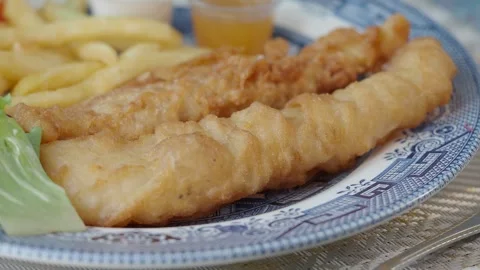 Enjoying fish and chips at a seaside restaurant Stock Footage 336652569