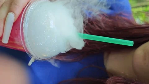 Enjoying a flavored drink with smoke effect in nature on a sunny day Stock Footage 340461971
