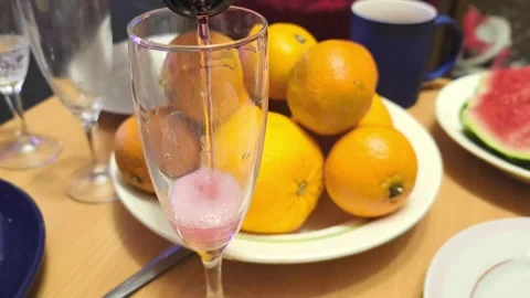 Enjoying fresh oranges and drinks on a dining table with friends at home in the Video stock 325793241