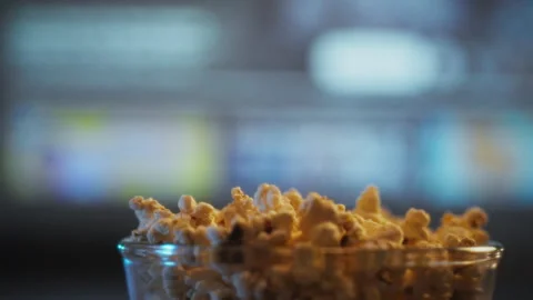 Enjoying freshly made popcorn during a cozy movie night at home with friends Stock Footage 323766850