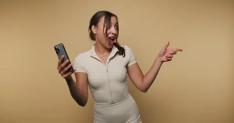 Enjoying a fun moment while dancing and using a phone at home during sunny .. Stock Footage 317397214