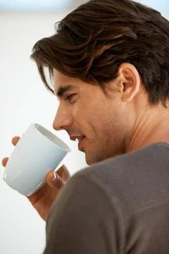 Enjoying his morning java. A handsome young man standing at home and holding a 스톡 사진