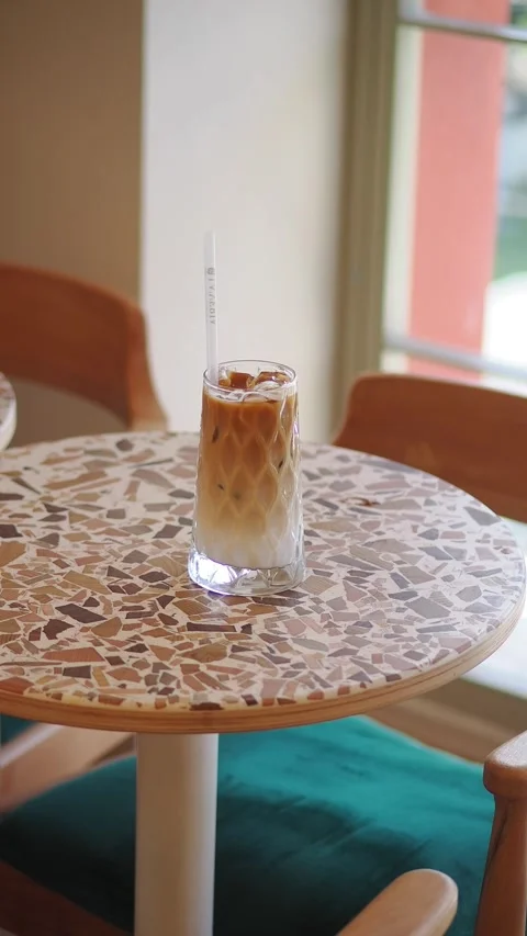 Enjoying iced coffee at a cafe table in the afternoon Stock Footage 342381933