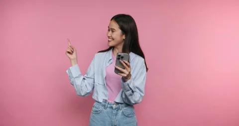 Enjoying a moment of joy while using a smartphone in a vibrant setting Stock Footage 317327705