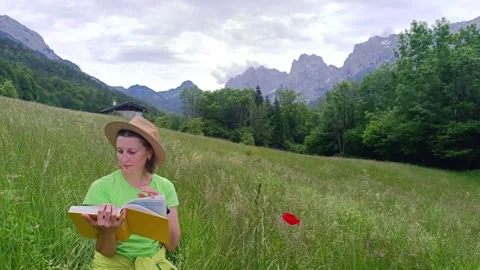 Enjoying nature while reading a book in the mountains on a sunny day Stock-Footage 310536809