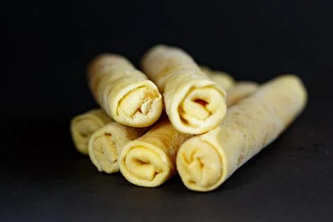 Enjoying pancake roll-ups stacked on a black plate for a sweet or savory sn.. Stock Photos
