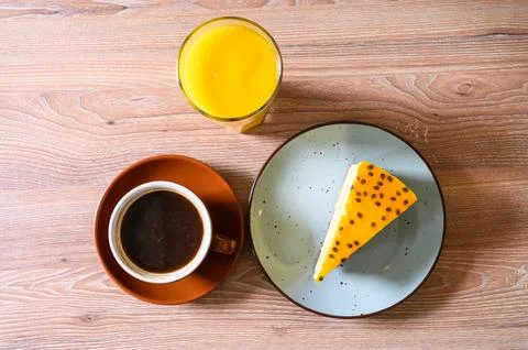 Enjoying a passion fruit cake slice with coffee and juice Stock Photos
