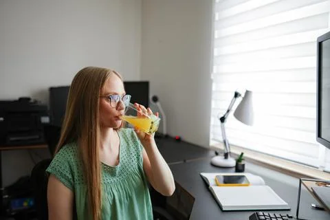 Enjoying a refreshing drink while working at a home office desk Stock Photos
