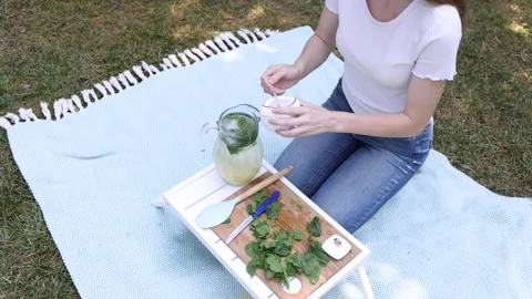 Enjoying a refreshing mint drink preparation on a sunny day outdoors Stock Footage 297370259