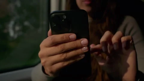 Enjoying a relaxing train ride while browsing on a smartphone, afternoon light Stock Footage 327119161