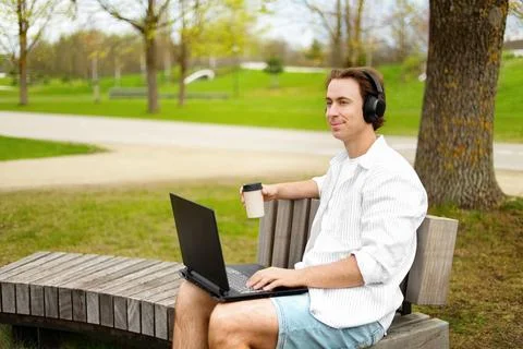 Enjoying remote work and freelancing, a smiling man is working on a laptop .. Foto stock