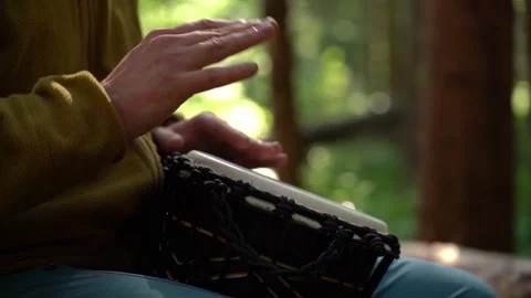 Enjoying rhythmic drumming in the forest while connected to nature Stockbeeldmateriaal 341874121