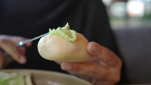 Enjoying a roll with avocado spread in a cafe Stock Footage 336227457