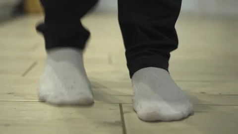 Enjoying the simple act of walking in cozy socks on a clean, polished wooden Stock Footage 318543762