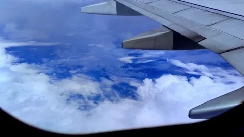 Enjoying the sky through an airplane window journey above the clouds Stock Footage 255551195