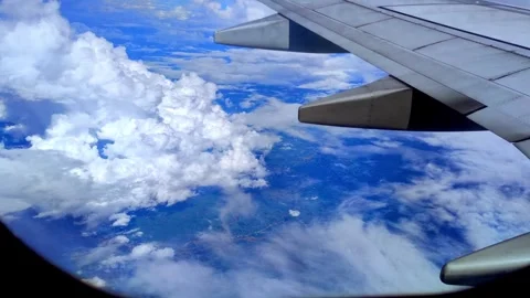 Enjoying the sky through an airplane window journey above the clouds Stock Footage 255551229