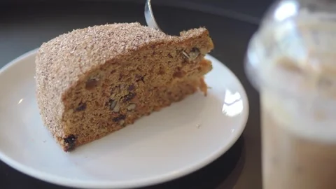 Enjoying a slice of cake with a drink in a cafe Stock Footage 337690356