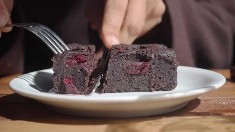 Enjoying a slice of chocolate dessert with cherry pieces Stock Footage 334908190