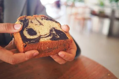 Enjoying a slice of marble bread in a cafe Stock-Fotos