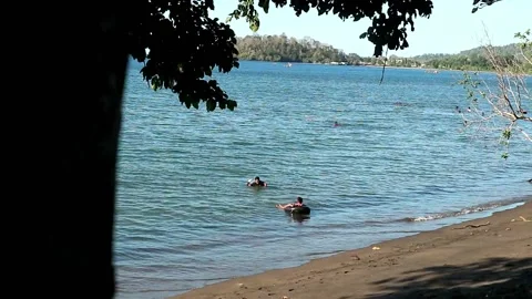 Enjoying the small waves with a rubber buoy Stock Footage 201030871