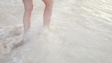 Enjoying a sunny day at the beach while splashing in the waves on a warm summer Stock Footage 306417247