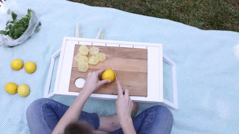 Enjoying a sunny picnic while preparing fresh fruit in the park Stock Footage 297368530