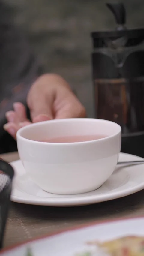 Enjoying tea at a cafe table in the afternoon Stock Footage 338152304
