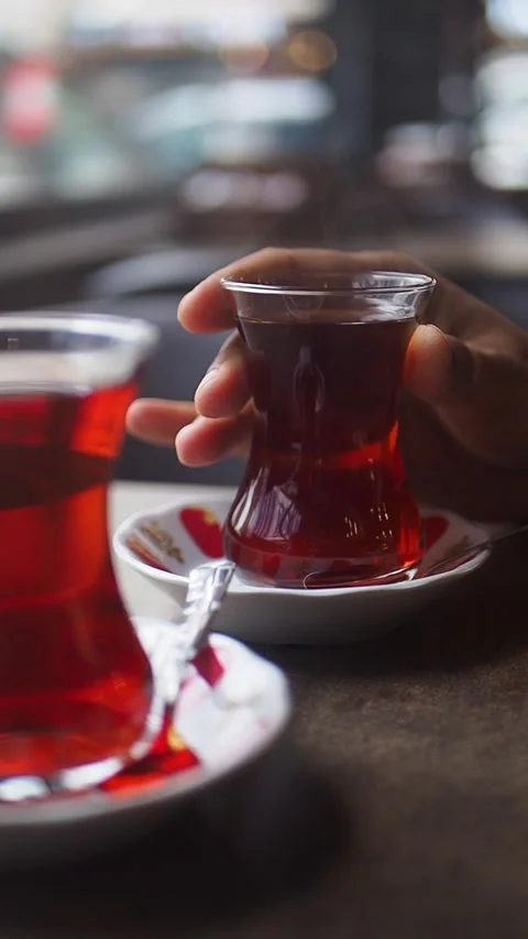 Enjoying tea at a cafe with two glasses on a table in the background Stock Footage 346338440