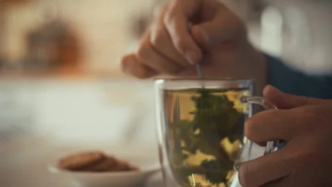 Enjoying a warm cup of herbal tea with cookies on a relaxing afternoon Stock Footage 323766775