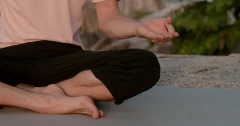 Enlightened person sitting on beach at sunset fingers in mudra gesture front Stock Footage 274518554