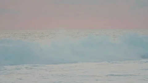Enormous blue waves breaking on the seashore under a peaceful pink sky at sunset Видео 342977113