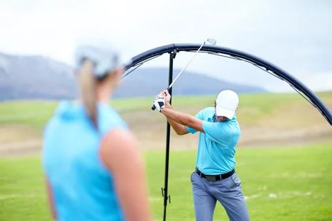 Ensuring she learns the perfect swing. Cropped image of a male coach instructing Fotos Stock