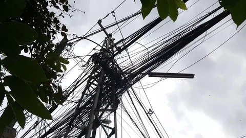 Entangled intersecting electric cables on poll, leaves, Vientiane, Laos Vídeos de archivo 75037318