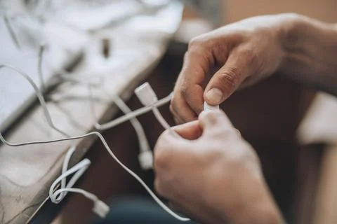 Entangled Solutions - A close-up of hands meticulously selecting the right cable Stock Photos