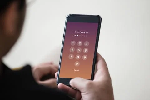 Enter Passcode concept. Man hand holding smartphone while entering the passcode. Stock Photos