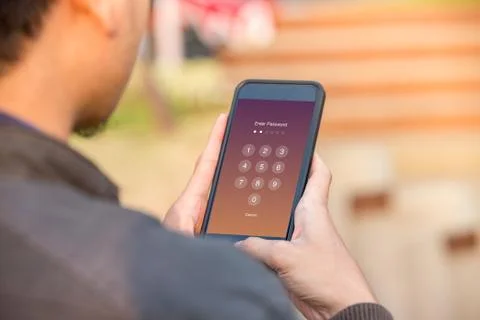 Enter Passcode concept. Man holding smartphone while entering the passcode. Stock Photos