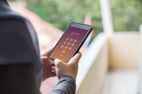 Enter Passcode concept. Woman hand holding smartphone while entering passcode Stock Photos