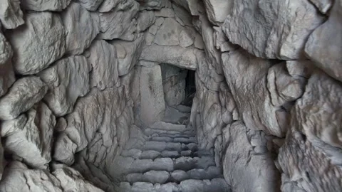 Enter a stone cave and go inside the rock under the ground, claustrophobia and a Stock Footage 276227076