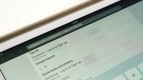 Entering adress of Facebook webpage on Apple Ipad display. Facebook is largest Stock Footage 80595016