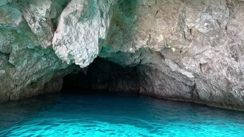 Entering Into a Cave at the Bottom of a Cliff Stock Footage 265502965