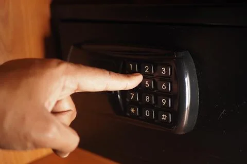 Entering a code on a safe in a modern setting 스톡 사진