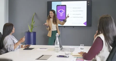 Entering conference room demonstrating app on monitor, woman presenter showing Stock Footage 317838280
