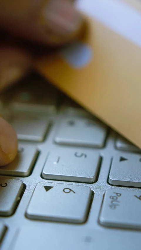 Entering CVV/CVC code on a laptop keyboard with a credit card in hand, onli.. Stock Footage 303741409