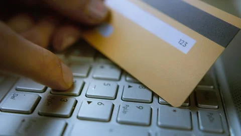 Entering CVV/CVC code on a laptop keyboard with a credit card in hand, onli.. Stock Footage 303940766