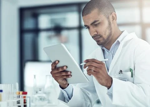 Entering data into the information system. Shot of a scientist recording his Stock Photos