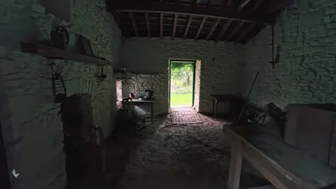 Entering a historic rustic stone barn with traditional tools and interior Stock Footage 348029537