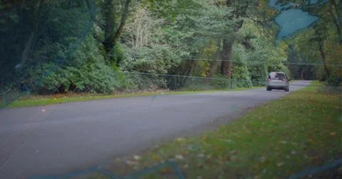 Entering left, silver van moving right along tree-lined road, faint map overlay Stock Photos