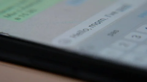 Entering message and texting to his mother on mobile phone, macro shot Stock Footage 111866404