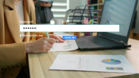 Entering password to sign in on a computer at an office desk Video stock 334022443